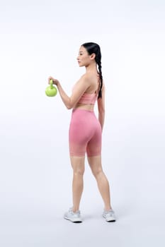 Vigorous energetic woman doing kettlebell weight lifting exercise on isolated background. Young athletic asian woman strength and endurance training session as body workout routine.