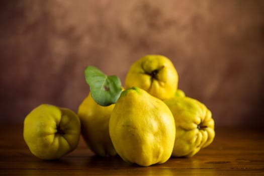 Ripe natural autumn quince on a dark wooden table.