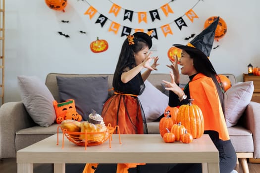 Mother and her daughter having fun at home. Happy Family preparing for Halloween.
