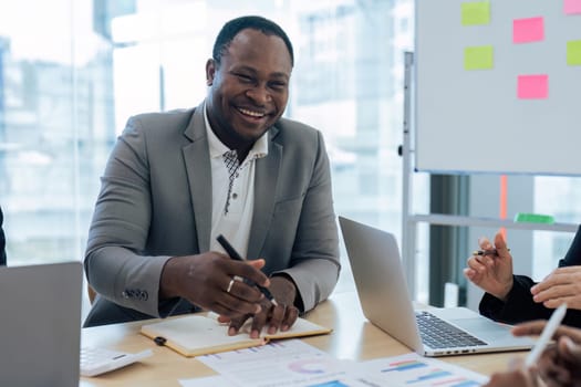 Female senior businessman brainstorming about marketing strategy report with diverse coworkers team.