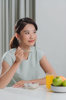 Young lady enjoying granola with milk for breakfast, free space. 