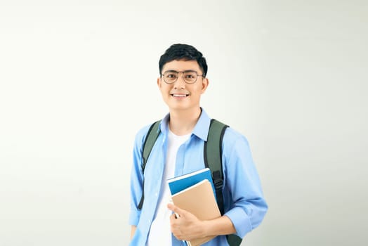 Smiling young man student with backpack hold books isolated on white background.