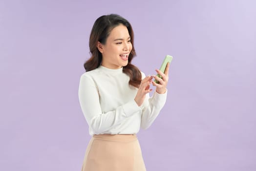 Happy Asian woman holding a smartphone and winning the prize.