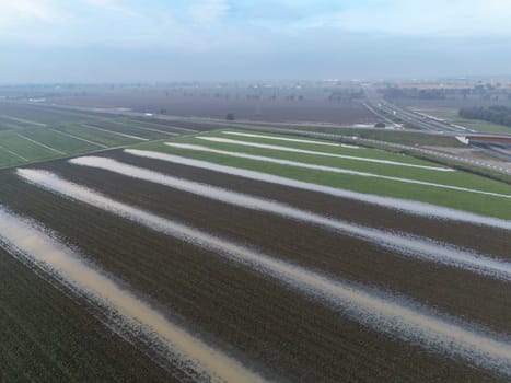 Overhead Aerial view of a flooded fields showcasing the impact of unusual heavy rainfall on rural landscapes during autumn