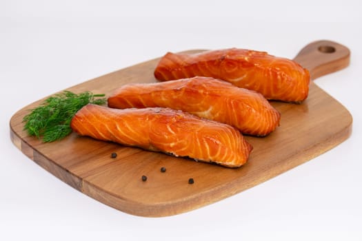 Enjoy grilled salmon fillets garnished with lemon zest and herbs, elegantly served on a rustic cutting board