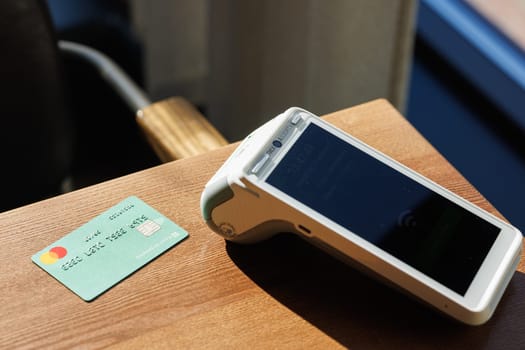 Close-up of payment terminal and credit card on table background. Paying for purchases with credit card. E-commerce. Business concept