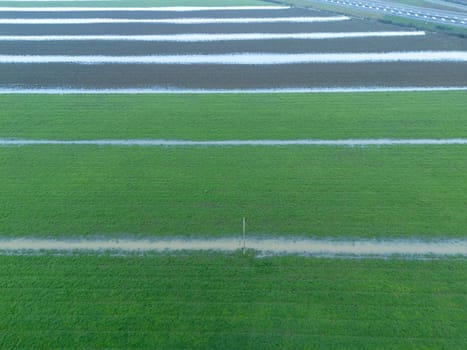 Overhead Aerial view of a flooded fields showcasing the impact of unusual heavy rainfall on rural landscapes during autumn