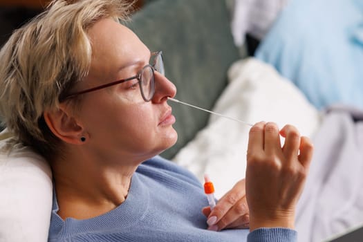 woman tests herself for new coronavirus strain at home, test for detection of covid-19 antigens and flu viruses, diagnosis of disease