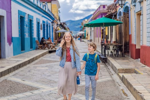 Mother and her son tourists walks through the colonial streets San Cristobal de las Casas, Mexico. Cultural exploration, architecture, and travel experience concept.