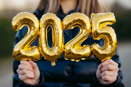 Happy new year. Portrait of a young woman holding 2025 new year gold foil balloon decoration..