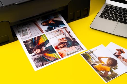 Printer printing colorful photos of people close up, yellow background, studio shot