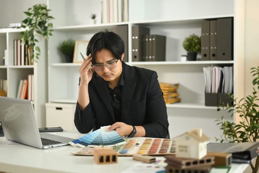 Serious interior designer considering color options for home renovation project.
