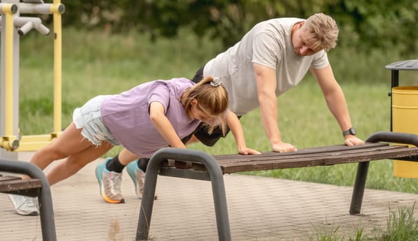 Father And Daughter Doing Push-Ups Together Outdoors