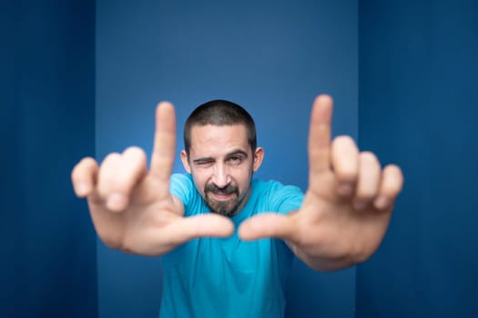 Young man doing frame using hands and fingers, isolated over purple background. High quality photo