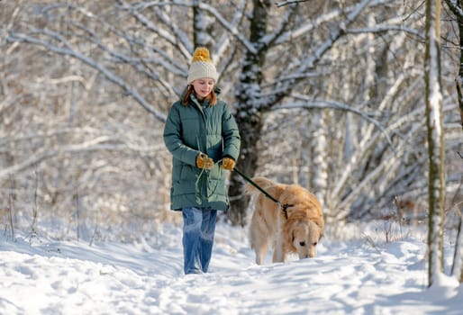 Girl Walks With Golden Retriever In Winter Forest, Strolling With Dog Through Snow-Covered Woods