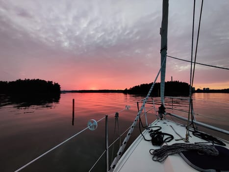 View from the bow of a sailing yacht on a beautiful red sunset in the Baltic sea