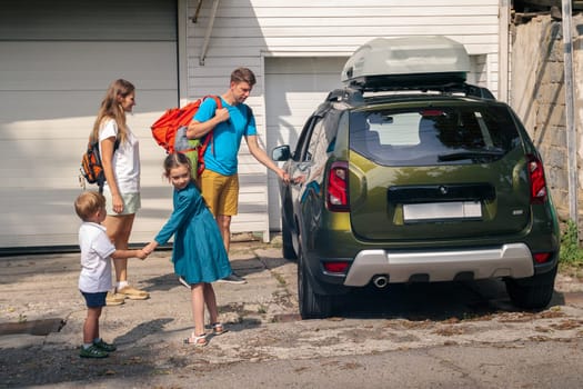 A joyful family is ready for an outing, with excited kids holding hands and luggage in a parked car