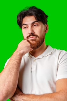 A man with a serious expression stands against a vibrant green background in studio