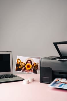 Computer laptop and printer on the table. Printing photos