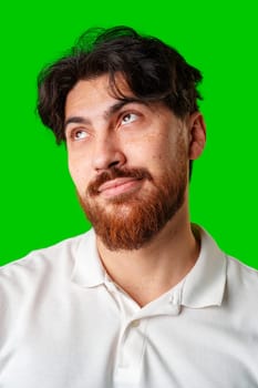 A man with a beard smiles confidently against a bright green background close up