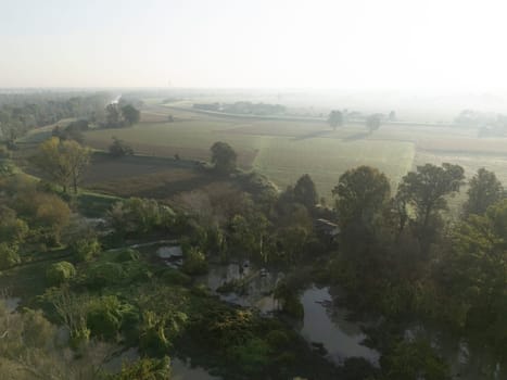 Castelvetro Piacentino. Italy - October 21st 2024 Muddy water is flooding the fields next to a river after heavy rain, damaging the vegetation putting the environment at risk caused by climate change