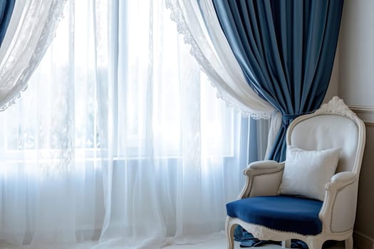 Sunlight filters through sheer white curtains, illuminating a stylish blue chair placed near a window in a cozy interior space.