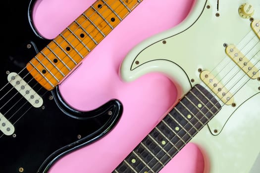 Electric guitar on a pink background, close-up, top view
