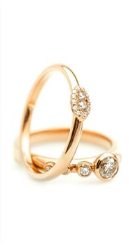 Two simple gold wedding rings are laying on white cloth, ready for the couple to exchange during their wedding ceremony