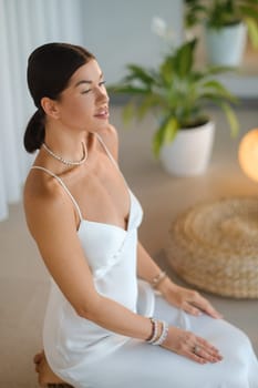 Girl in white dress does aesthetic gymnastics in gym. Girl doing yoga in the gym.