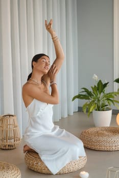 Girl in white dress does aesthetic gymnastics in gym. Girl doing yoga in the gym.