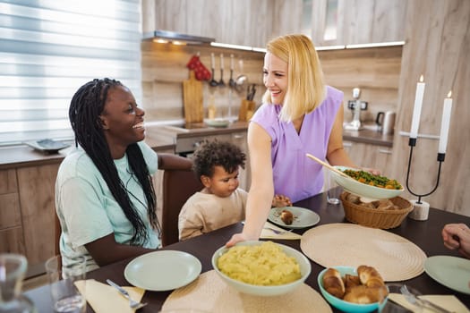Friends share laughter and delicious homemade food at the dinner table.