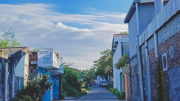 A road in the middle of village. Colorful buildings. Blue sky filled with clouds