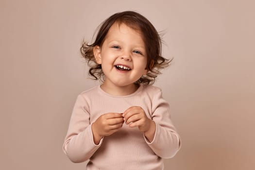 smiling child girl holding fruit pastille on beige background. healthy baby food.