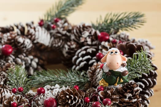 A small figurine of Santa Claus in a red and white suit holding a green sack, set against a blurred background. This festive ornament captures the spirit of Christmas.