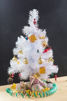 Small Christmas tree sitting on top of stool in a minimal room