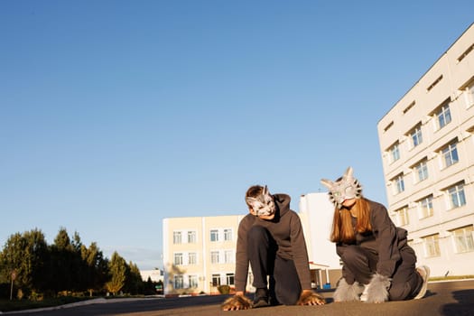 girl and boy in cat masks and cat costumes doing Quadrobics in the city, animal behavior simulation, Quadrobics sport