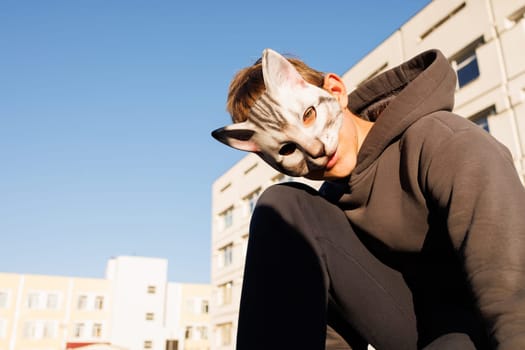 Teenage boy in cat mask and gloves playing Quadrobics. animal behavior imitation, style quadrobic, sport