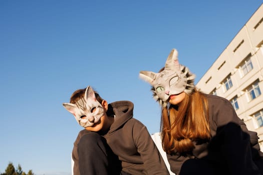 girl and boy in cat masks and cat costumes doing Quadrobics in the city, animal behavior simulation, Quadrobics sport