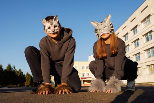 girl and boy in cat masks and cat costumes doing Quadrobics in the city, animal behavior simulation, Quadrobics sport