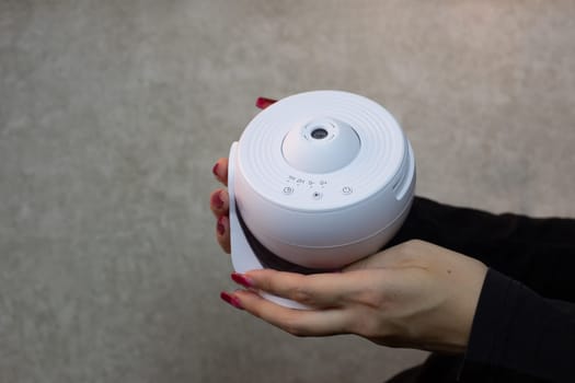 Galaxy projector for learning at home in hands of girl, compact projector for space exploration with replaceable cartridges for projecting images of milky way with stars and planets