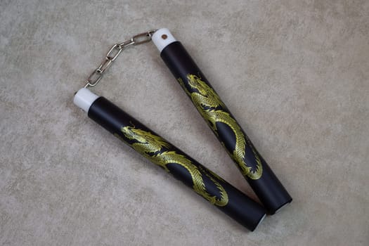 Black nunchucks with golden dragon for martial arts training, special ancient weapons for self defense. Body agility training with soft material nunchuck, martial arts culture using weapons