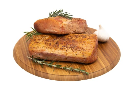 Smoked ham on a rustic wooden board with fresh rosemary. Natural product from an organic farm, produced using traditional methods.
