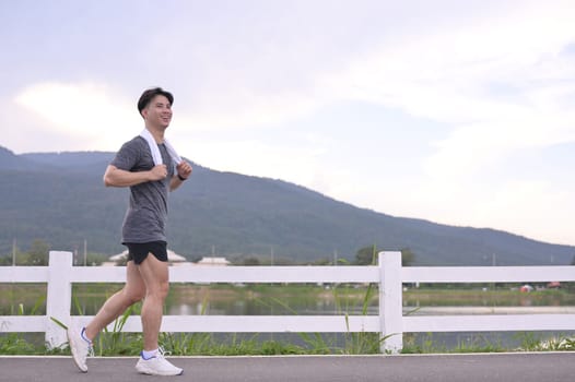 Young athlete running with scenic mountain views. Healthy lifestyle concept.