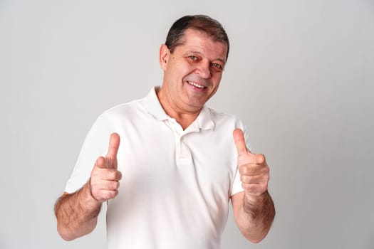 An older man smiling and reaching out with both hands in studio