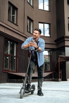 Young man enjoying a sunny day while riding an electric scooter through a modern urban setting close up