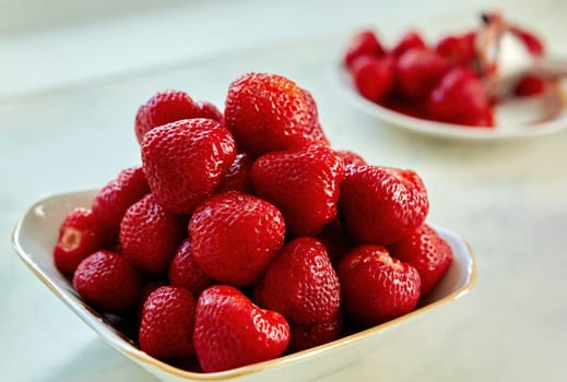 A vibrant collection of freshly harvested strawberries piled high in an elegant bowl on a bright kitchen countertop