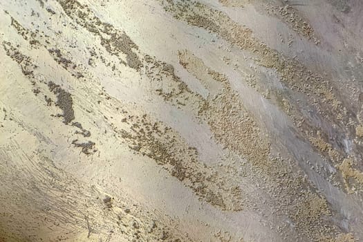 Golden texture of decorative Venetian plaster close-up