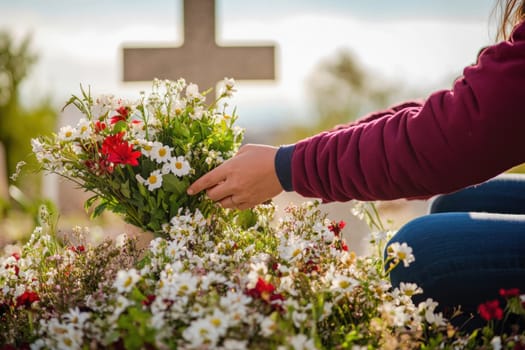Woman arranging flowers by a fresh grave in a cemetery