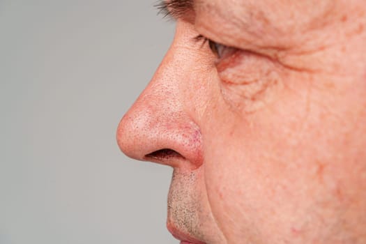 Portrait of a mature man with short hair and a neutral expression, captured in a studio setting close up