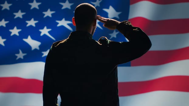 Soldier saluting USA flag, participating in 4th of July celebrations. United States of America veteran honoring country during memorial day event, doing patriotic hand gesture towards flag, camera A